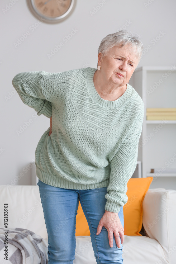 Senior woman suffering from back pain at home