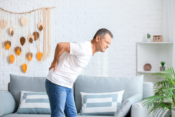 Wall Mural - Mature man suffering from back pain at home