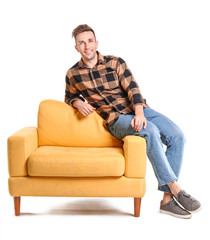 Handsome man sitting on armchair against white background