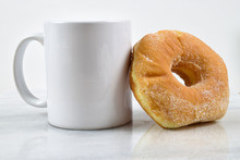 Fresh Sugar Donut Resting Against White Coffee Cup