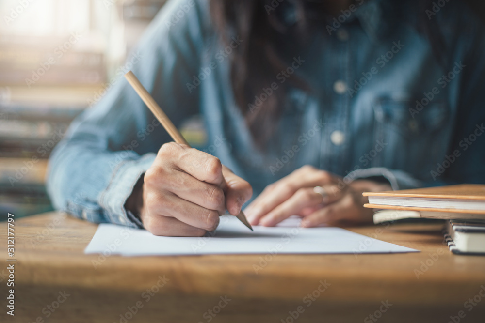 high school,university student study.hands holding pencil writing paper answer sheet.sitting lecture chair taking final exam attending in examination classroom.concept scholarship for education abroad - obrazy, fototapety, plakaty 