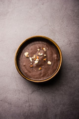 Canvas Print - Sweet Ragi Malt / Healthy Ragi Porridge in a bowl garnished with crushed dry fruits