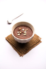 Canvas Print - Sweet Ragi Malt / Healthy Ragi Porridge in a bowl garnished with crushed dry fruits