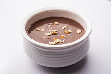 Wall Mural - Sweet Ragi Malt / Healthy Ragi Porridge in a bowl garnished with crushed dry fruits