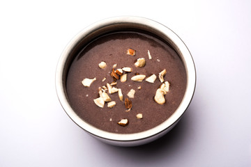 Canvas Print - Sweet Ragi Malt / Healthy Ragi Porridge in a bowl garnished with crushed dry fruits