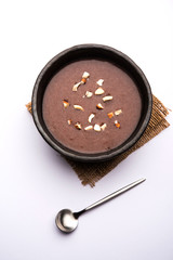 Wall Mural - Sweet Ragi Malt / Healthy Ragi Porridge in a bowl garnished with crushed dry fruits