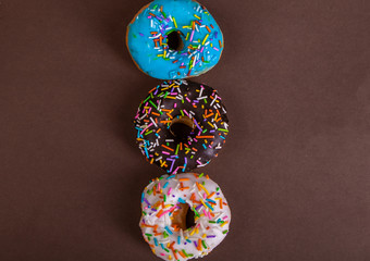 Wall Mural - colorful doughnuts brown background studio