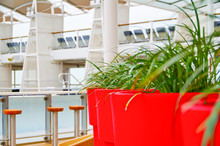 Pool Bar On Outdoor Deck Of Celebrity Cruises Luxury Cruise Ship Liner With Red Plant Pots And Superstructure In The Background
