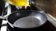 © procinemastock - Olive oil on black frying pan.