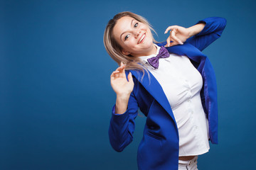 Wall Mural - jumping and dancing businesswoman in stylish blue jacket and bow tie. Portrait of a cheerful girl