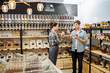 © Iryna - choosing in grocery shop. Zero waste shopping - man buying healthy food in bulk products in dispensers and food available. Sustainable shopping at small local businesses.
