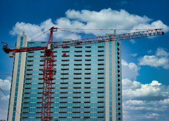 Canvas Print - Highrise tower behind construction crane