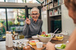 © bnenin - Portrait of a senior woman enjoying meal with family.