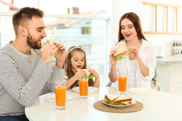 Poster - Happy family having breakfast with sandwiches at table in kitchen