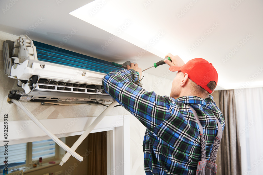 Air conditioner service. Worker at climatization system installation ...