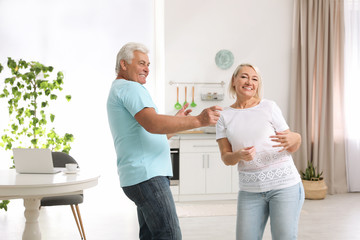 Sticker - Happy mature couple dancing together in kitchen