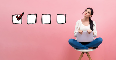 Wall Mural - Checklist with young woman using a laptop computer