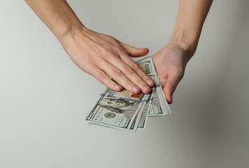 female hands scatter one hundred dollar bills on white background. Rich life concept