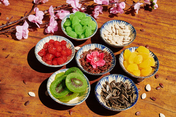 Wall Mural - Seeds, dried berries and fruits served in small ceramic bowls for Lunar New Year