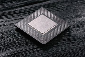 Computer cpu chip on black wooden background.