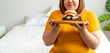 Hungry overweight young asian woman holding hamburger, Her hungry all time and overeat, gluttony and binge eating. Her lifestyle is eating fast food all time. Unhealthy Concept