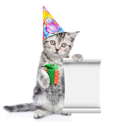 Poster - Cat wearing a birthday hat holds empty list and gift box. isolated on white background