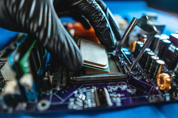 Wall Mural - Engineer repairman holding hands CPU to insert into the socket of the motherboard. Technology hardware in the neon light