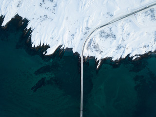 aerial drone view of bridge in norways ice and snow landscape - top down