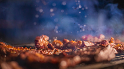 grilling meat on fire with pepper