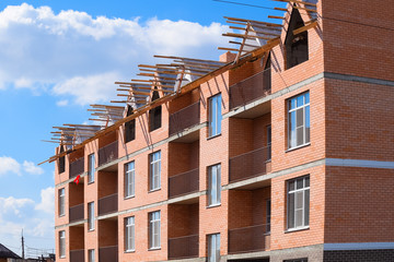 Wall Mural - three-storey brick apartment building under construction. Share building.