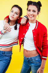 lifestyle people concept: two pretty young school teenage girls having fun happy smiling on yellow background