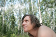 © lisaveya - An elderly man with long hair in a birch grove looks carefully. Russian
