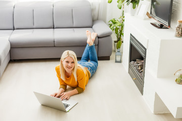 Wall Mural - woman sitting on sofa with laptop