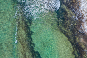 Wall Mural - aerial view of the texture of the surface of turquoise water with sun reflections