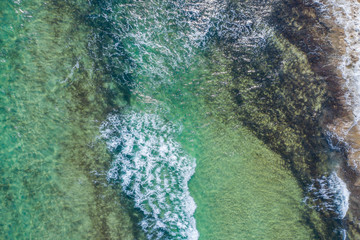 aerial view of the texture of the surface of turquoise water with sun reflections