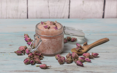 Homemade spa of rose bath salts on a light wooden background. Cosmetics and natural medicine