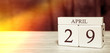 Calendar reminder event concept. Wooden cubes with numbers and month on April 29 with sunlight.