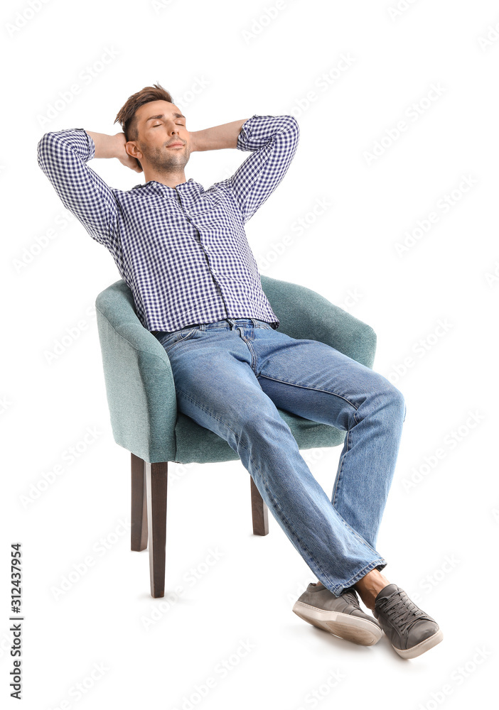 Handsome man sitting in armchair on white background
