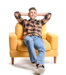 Wall Mural - Handsome man sitting in armchair on white background