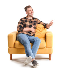 Poster - Handsome man sitting in armchair on white background