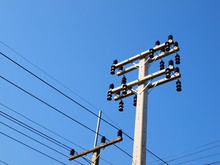 New Electricity Poles And Old Electricity Poles Preparation For Electrical Substitution According To The Growth Of The City Or Community. On A Blue Sky Background With Copy Space