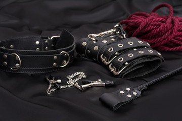 Wall Mural - Leather handcuffs, shibari rope, nipple clamps, chain collar and stack on black