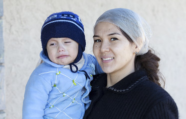 dissatisfied child in hand smiling mother