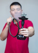 The guy smokes a hookah, exhales smoke. Portrait of a young man in smoke on white background
