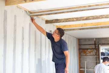 Sheathing, insulation of the container. Workers insulate an iron container for a residential building