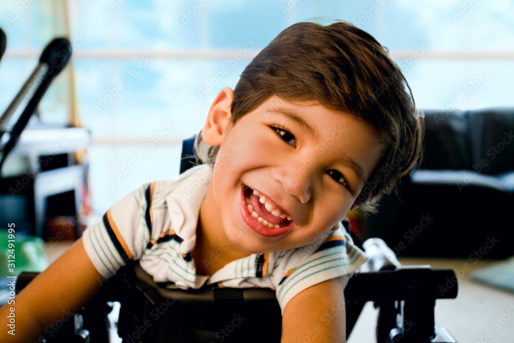 Happy smiling biracial disabled little boy standing in walker - obrazy, fototapety, plakaty 