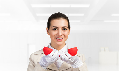 Smiling young woman holding retro red phone