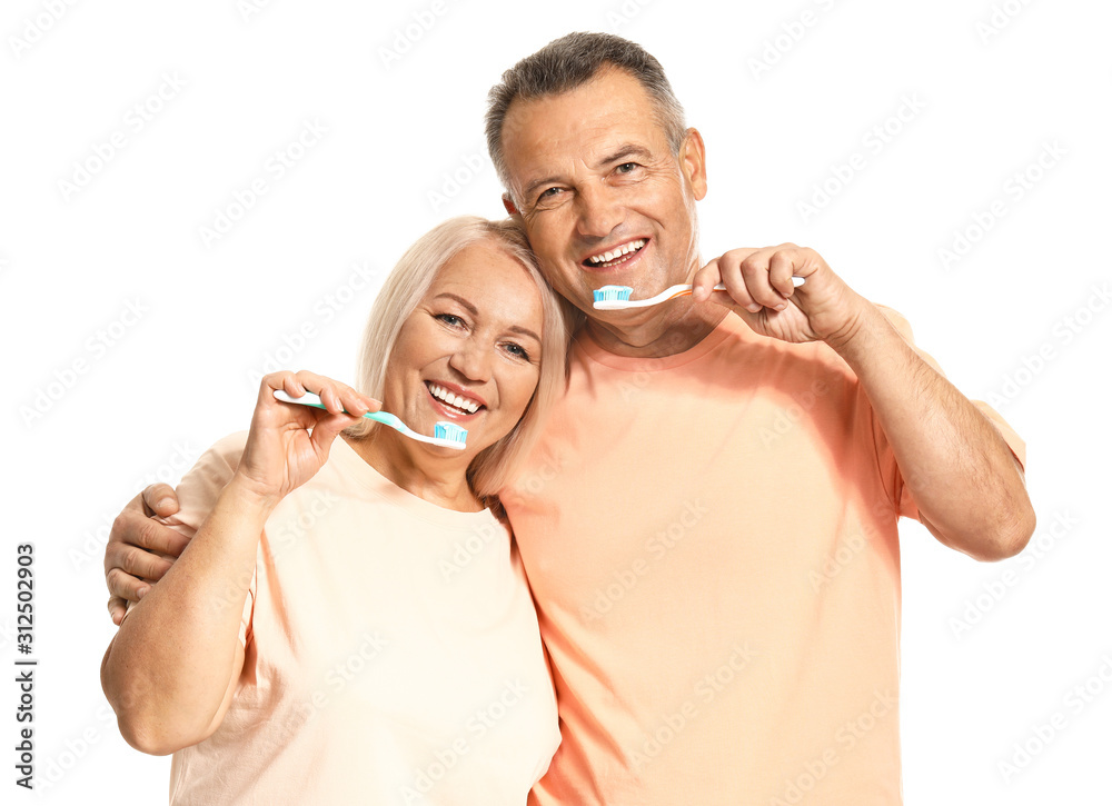 Mature couple brushing teeth on white background