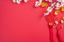 Design Concept Of Chinese Lunar New Year - Beautiful Chinese Knot With Plum Blossom Isolated On Red Background, Flat Lay, Top View, Overhead Layout.