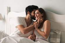 Affectionate Young Couple Relaxing In Bed And Having A Romantic Moment